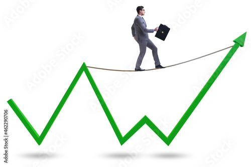 Businessman balancing on tightrope on line chart