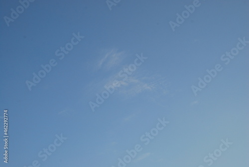 A cloud against a light blue sky. A small blurry white cloud is barely noticeable against the background of a clear blue sky. Summer sunny day.