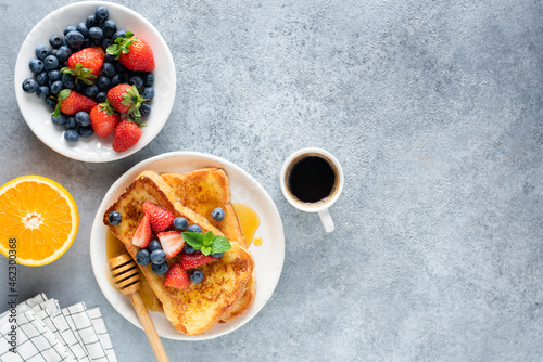 Fototapeta Naklejka Na Ścianę i Meble -  Sweet french toast with berries and cup of coffee on concrete background. Top view, copy space. Breakfast or sweet brunch food