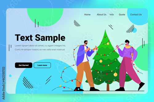 couple in santa hats decorating christmass tree merry xmas happy new year holiday celebration concept