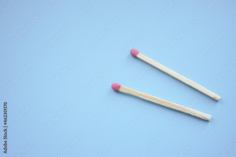two matches on a blue paper table