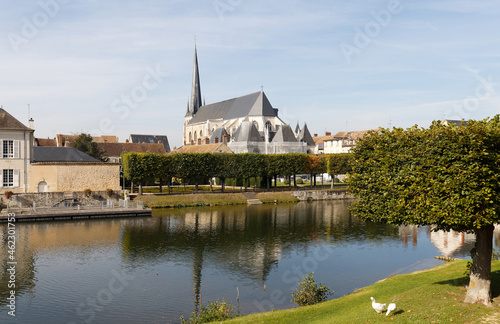 The view of church Saint Jean-Baptiste that dominates the Loing. Its architecture is enhanced by the elegance of its slate roofs. Nemors. France. photo