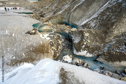 People are exploring the graphic details, textures and ice formations of the Athabasca Glacier