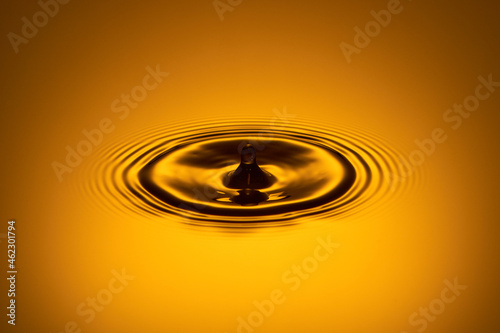A drop of water in the bouncing process
  from the surface of the golden water.
