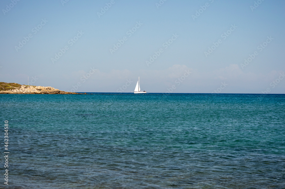 White boat sailing in the open blue aegean sea in Greece