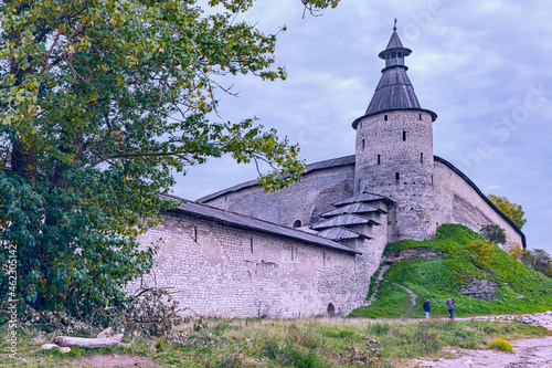 fragment of an old fortress wall with a corner watchtower in the ancient Russian city of Pskov