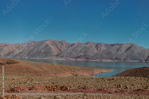 Africa Morocco desert Atlas mountains nature rock landscape with river palm under blue sky hot weather 