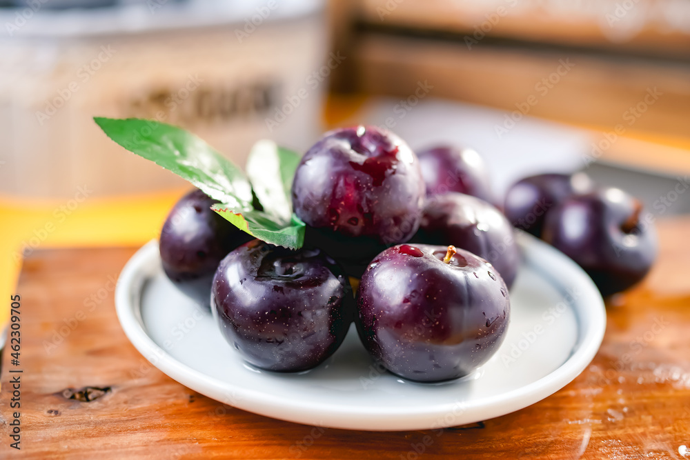Fresh black plums on cutting board