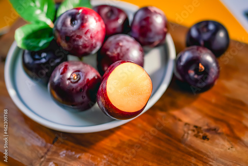 Fresh black plums on cutting board