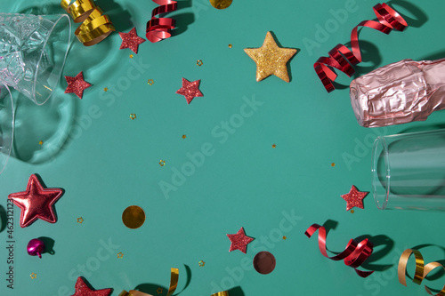 Festive Meryy Christmas or New year colorful background with champagne, glass, stars, streamers flat lay with copy space photo