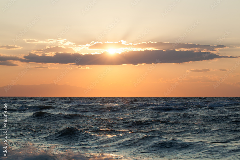 Rough sea and sunset over it