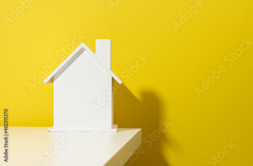 white wooden house on a yellow background. Real estate rental, purchase and sale concept. Realtor services