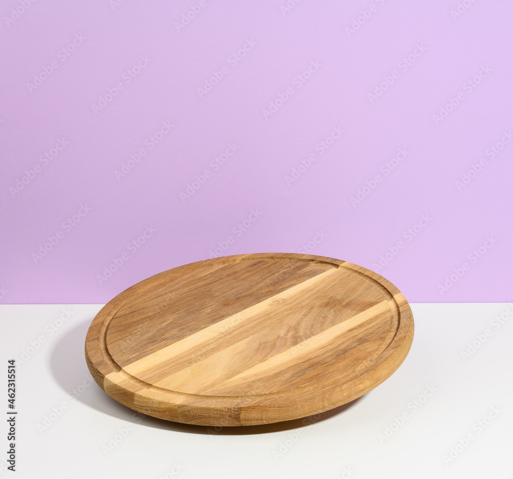 round wooden kitchen pizza board on a purple background, utensils levitate