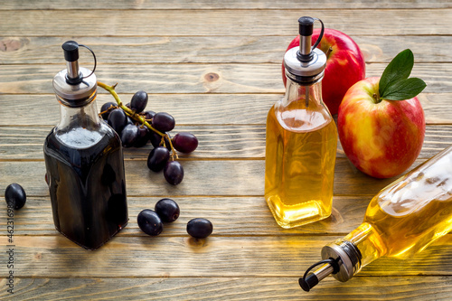 Foto Apple cider and balsamic vinegar in bottles with grapes and red apples
