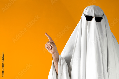 Fotobehang Person in Halloween costume of ghost with sunglasses points away
