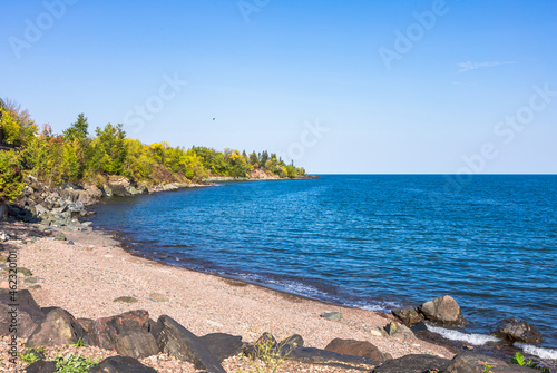 Fototapeta Naklejka Na Ścianę i Meble -  Sea horizon, calm ocean, tropical lake among bush natures. Deep blue water, sand beach and clear sky, selective focus. Seascape view in autumn. Tranquility scene. Vacation concept. Natural background.