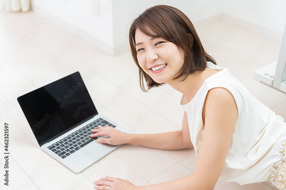 部屋でラップトップコンピューターを見る女性 部屋でラップトップコンピューターを見る女性