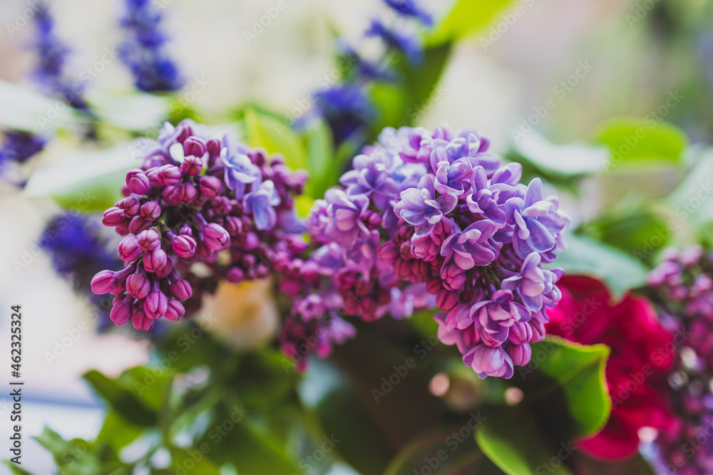 close-up of bunch of purple flowers including lillac in vase indoor by the window close-up of bunch of purple flowers including lillac in vase indoor by the window