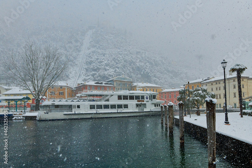 View of the beautiful Lake Garda surrounded by mountains,Riva del Garda town and Garda lake in the winter time on a snowy day,Trentino Alto Adige region