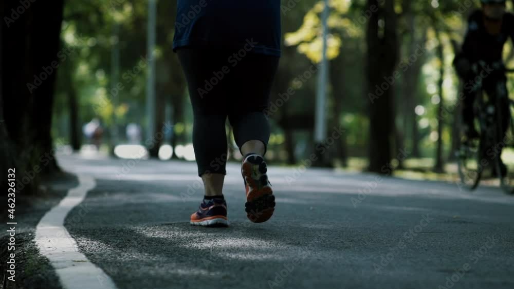 Crowd of urban population enjoying early morning walk, exercising and riding bicycle early in park during the weekend break recreational activities Crowd of urban population enjoying early morning walk, exercising and riding bicycle early in park during the weekend break recreational activities