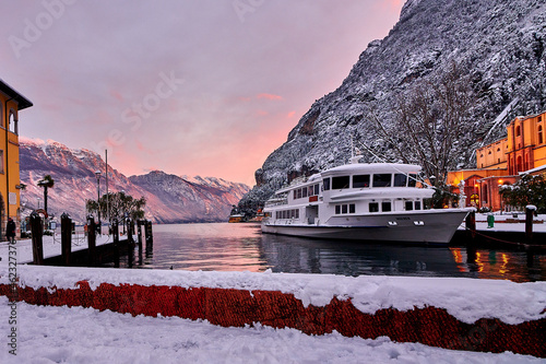View of the beautiful Lake Garda surrounded by mountains,Riva del Garda town and Garda lake in the winter time on a snowy day,Trentino Alto Adige region