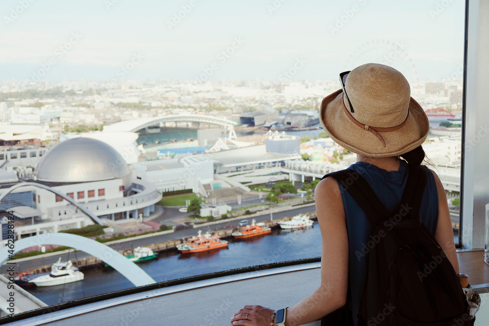 展望室から名古屋港を眺める女性
