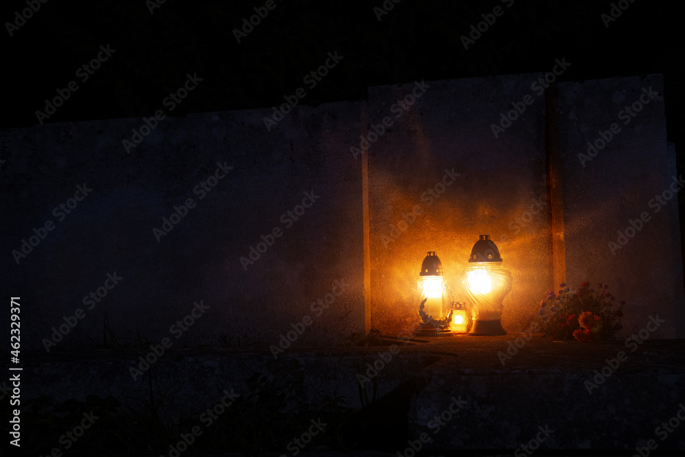 night cemetery background tombstone with memorial lamps flame warm light, soft focus concept with empty copy space for thematic text