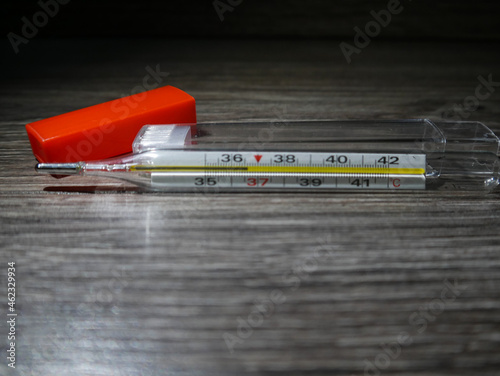 thermometer lying on a black wooden background, treatment, illness, temperature
