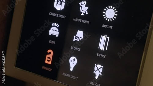 This video shows a hand presses lighting touch pad buttons close up on a smart home tech panel. photo