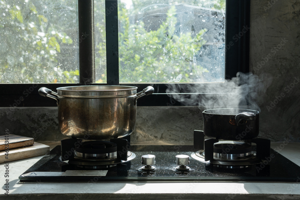Selective focus. Boiling water with steam in a pot on an electric stove in the kitchen Selective focus. Boiling water with steam in a pot on an electric stove in the kitchen