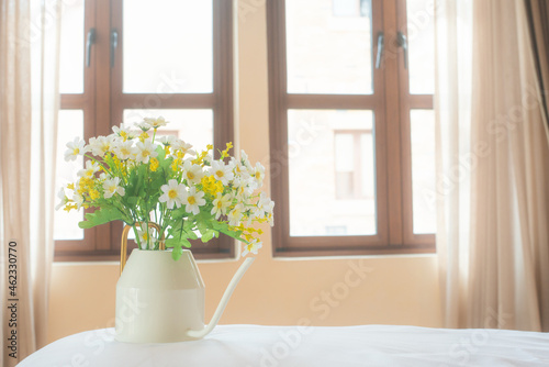 Platic white flower decoration in house with sunny day background.