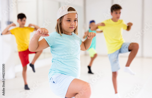 Girl in white cap dancing hip-hop with his mates during groung dance class.