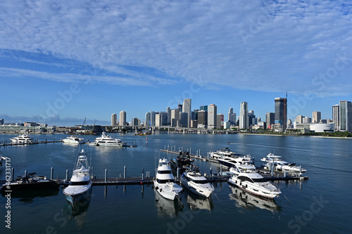 Island Gardens Deep Harbour Marina under summer cloudscape with City of Miami skyline and Port Miami in background.