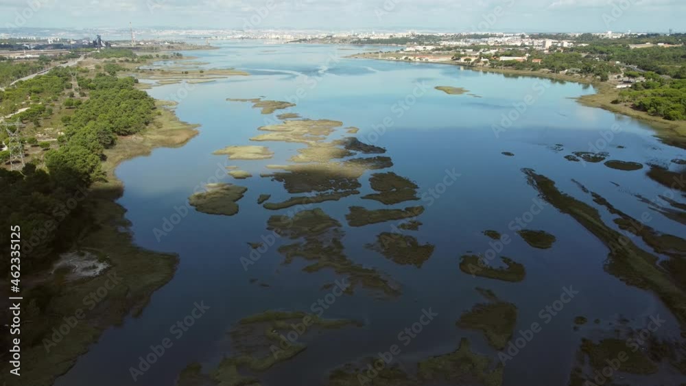 Aerial descend flight over wide swampland with green islands during sunlight in Portugal - Shadow of clouds in marshland Aerial descend flight over wide swampland with green islands during sunlight in Portugal - Shadow of clouds in marshland