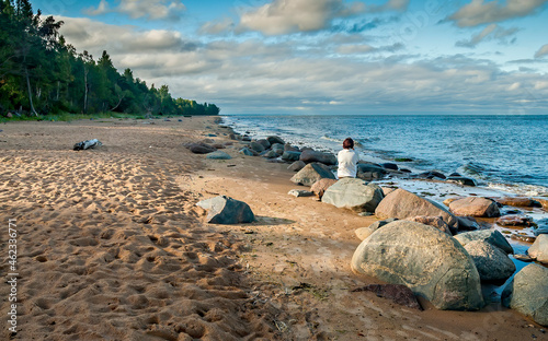
Stony beach of the Baltic Sea at autumnal weather and single woman looking at the distance
 photo