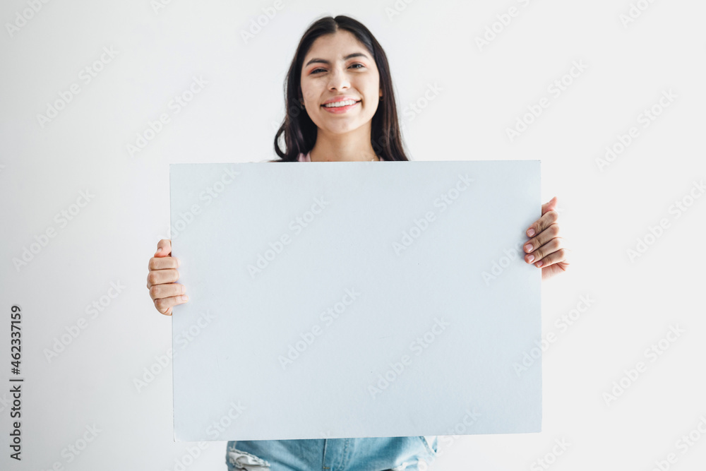 Young latin woman holding a blank empty card isolated on white background in Latin America Young latin woman holding a blank empty card isolated on white background in Latin America