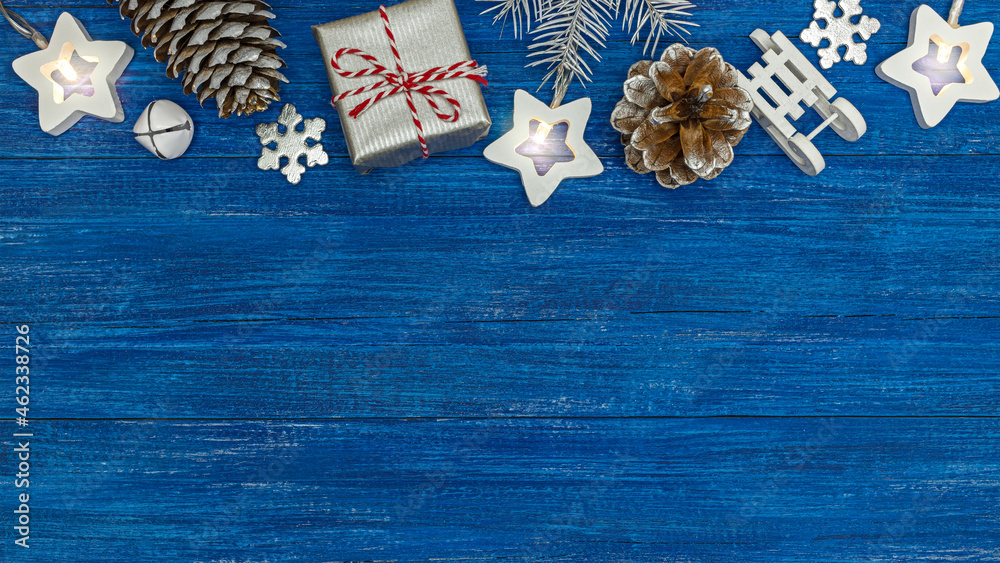 winter xmas holiday theme. silver gift box with christmas decorations on weathered blue boards background. top view.