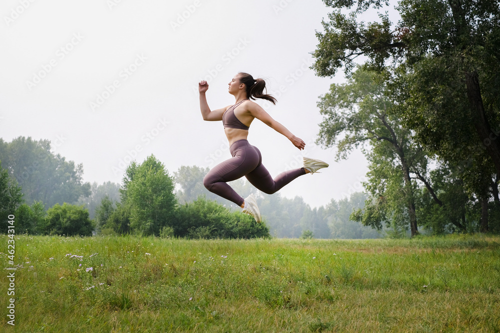 Young woman doing yoga on mat at summer park. Healthy sport lifestyle concept. Active and athletic female exercises Young woman doing yoga on mat at summer park. Healthy sport lifestyle concept. Active and athletic female exercises