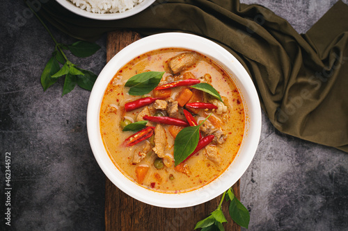 Panang Curry with Pork served with rice on a dark background.