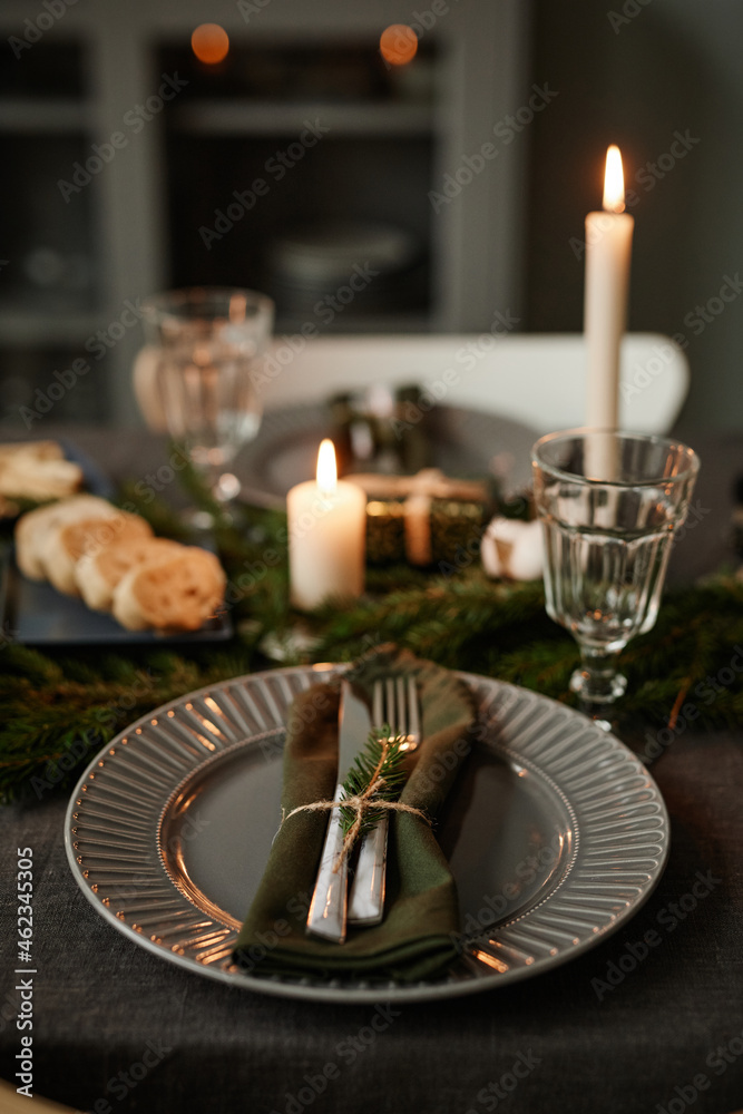 Vertical background image of black table setting decorated for Christmas with candles lit, copy space