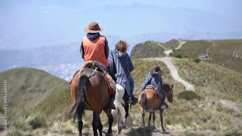 Tourists are riding horses on a trail of Rucu Pichincha near Quito Ecuador. They are wearing ponchos. Tourists are riding horses on a trail of Rucu Pichincha near Quito Ecuador. They are wearing ponchos.