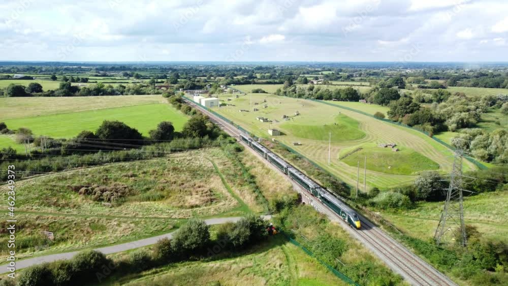 Train driving along tracks in countryside through fields, sunny day Train driving along tracks in countryside through fields, sunny day