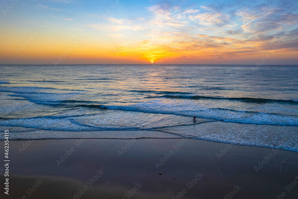 Aerial sunrise seascape with high cloud and gentle surf