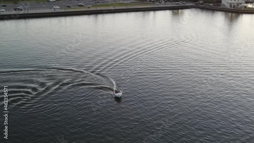 Tourist On The Speedboat Speeding Down In Lake Pontchartrain During Golden Sunset In New Orleans, USA. aerial photo