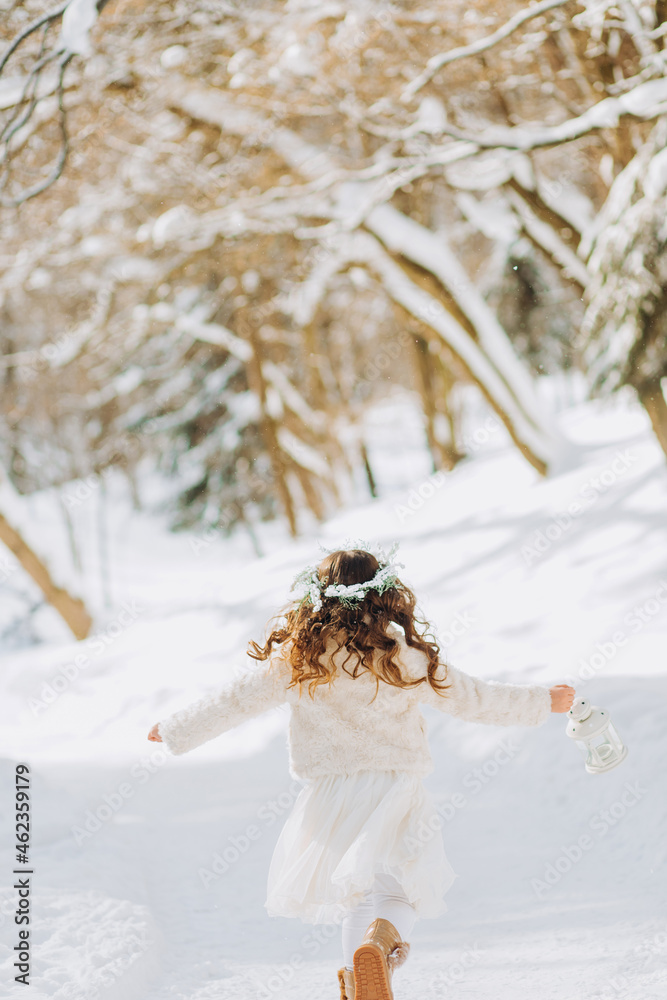 Fototapeta premium Amazing little girl holding Christmas lantern outdoors on beautiful winter sunny day