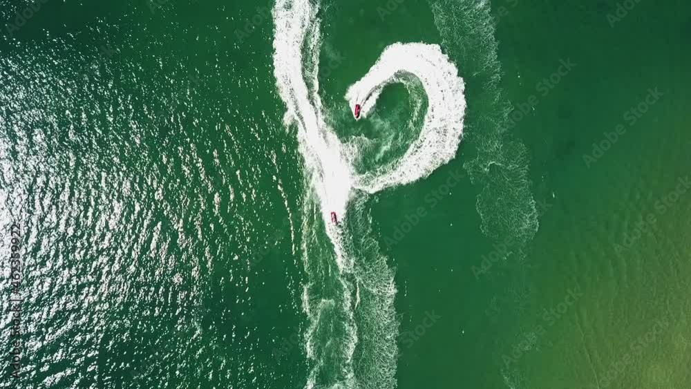Bird's eye view of water scooters doing stunts and tricks