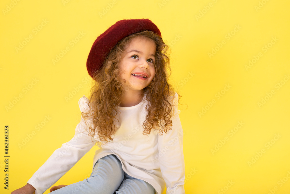 Portrait of a little curly 3-year-old girl with a hat on her head Portrait of a little curly 3-year-old girl with a hat on her head