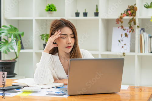 Overworked businesswoman suffering from headache and thinking how to end work. © PaeGAG