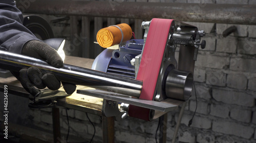 Working process on lathe with grinding belt in workshop photo