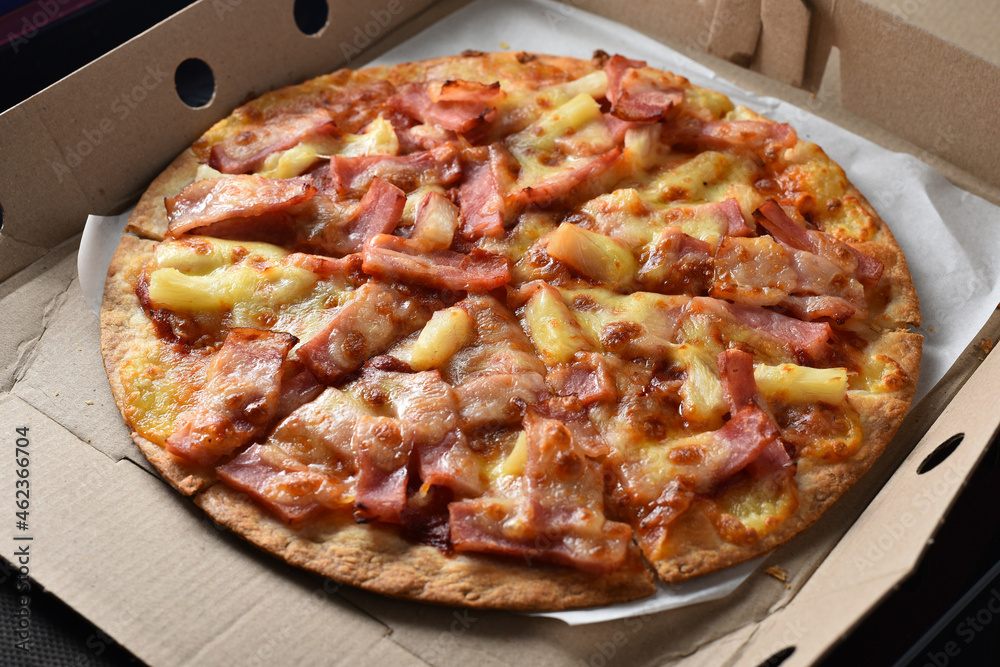Pineapple and ham pizza in a cardboard box full. Pineapple and ham pizza in a cardboard box full.